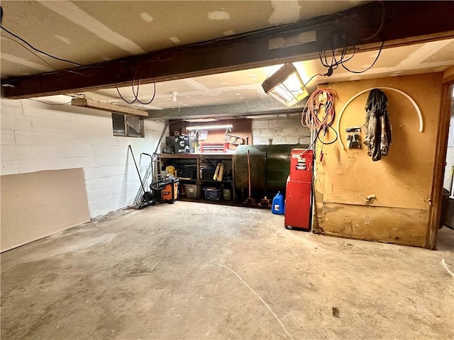 unfinished basement with concrete block wall and heating fuel