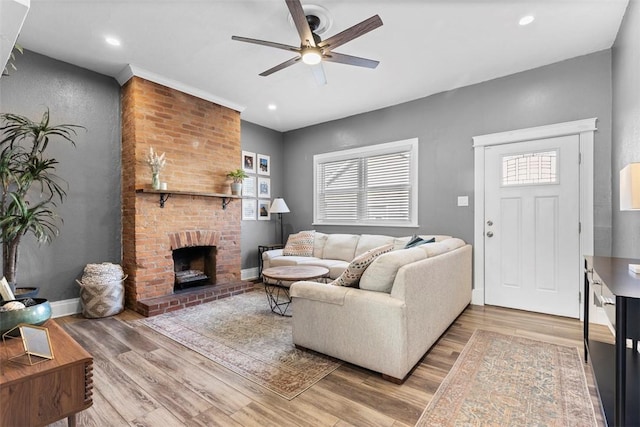 living area with a brick fireplace, wood finished floors, and a healthy amount of sunlight