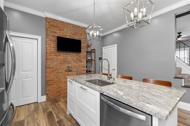 kitchen featuring dark wood-style flooring, appliances with stainless steel finishes, ornamental molding, white cabinetry, and a sink