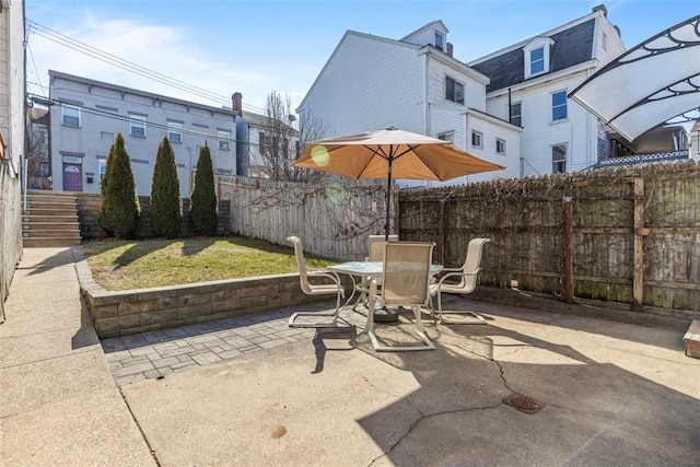 view of patio with outdoor dining space and fence