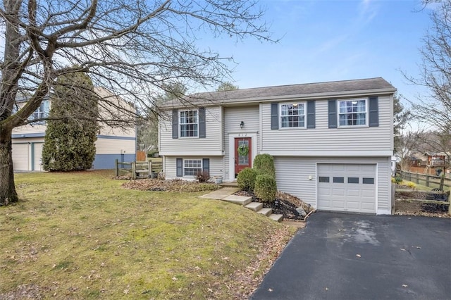 bi-level home with a garage, aphalt driveway, and a front yard