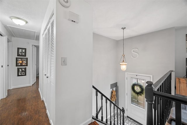 hallway with attic access, baseboards, wood finished floors, and an upstairs landing