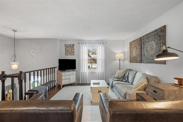 living room with a textured ceiling and baseboards