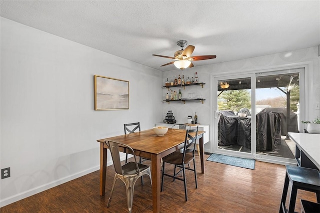 dining room with ceiling fan, a textured ceiling, baseboards, and wood finished floors