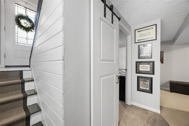 interior space with a textured ceiling and baseboards