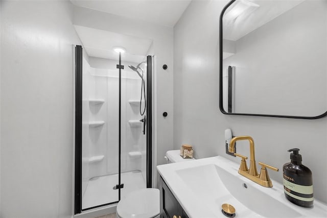 bathroom featuring toilet, a stall shower, and vanity