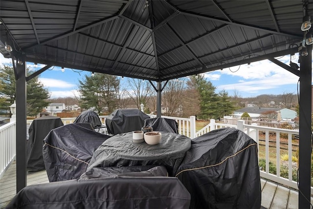 wooden terrace with a gazebo and area for grilling