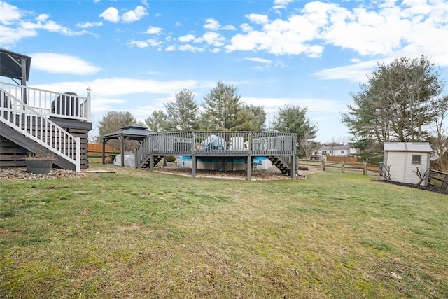 view of yard with an outdoor structure, fence, a gazebo, stairway, and a shed