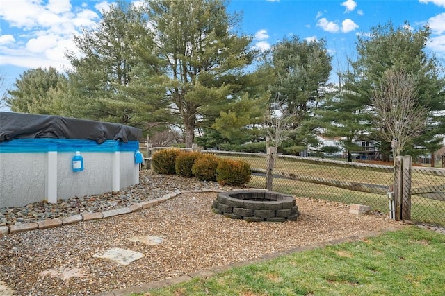 view of yard with a fire pit and fence