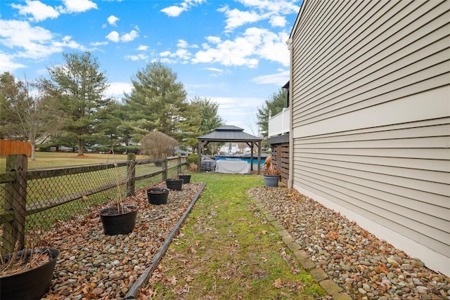 view of yard with fence, a fenced in pool, and a gazebo