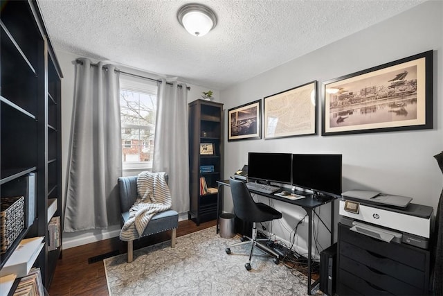 office space featuring a textured ceiling, baseboards, and wood finished floors