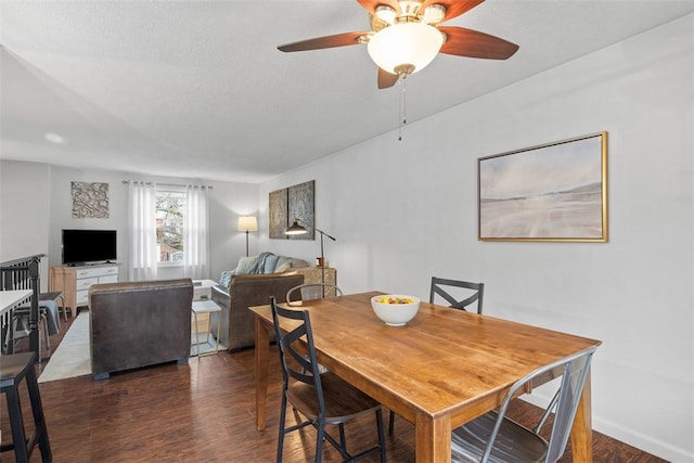 dining room with a textured ceiling, wood finished floors, a ceiling fan, and baseboards