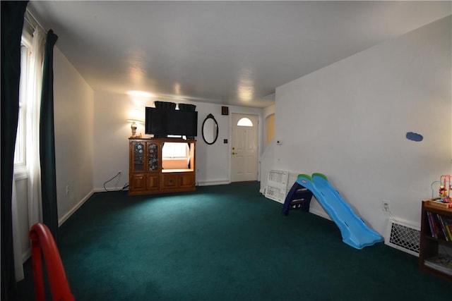 interior space with visible vents, dark carpet, and baseboards