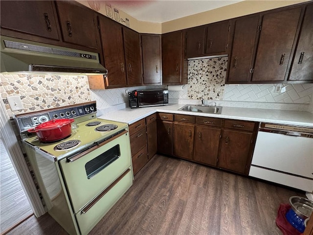 kitchen featuring dark wood-style floors, white appliances, light countertops, and a sink