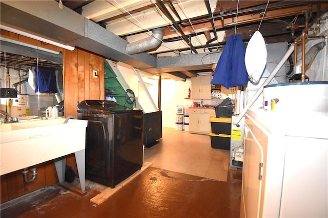 unfinished basement with washer and dryer, gas water heater, and a sink