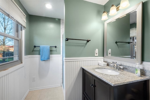 bathroom featuring tile patterned flooring, a wainscoted wall, and vanity