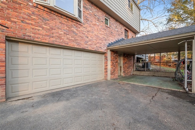 exterior space with driveway, a garage, and brick siding