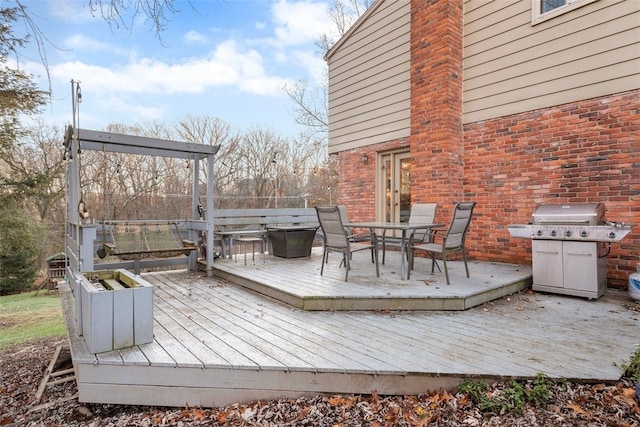 deck with outdoor dining area and grilling area