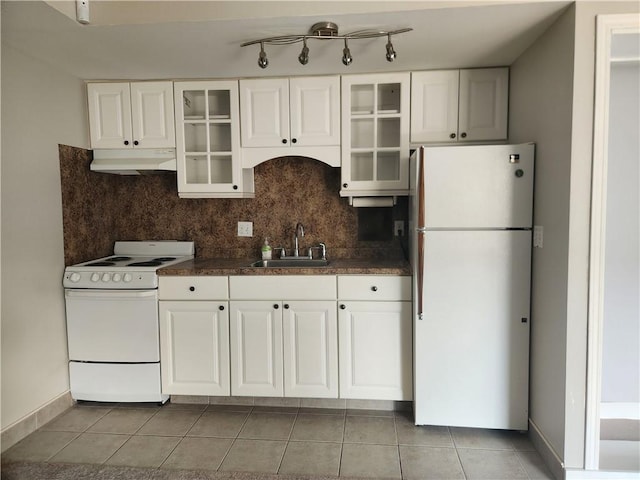 kitchen with under cabinet range hood, white appliances, a sink, white cabinetry, and decorative backsplash