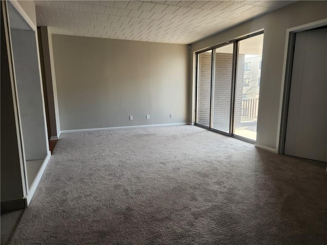 unfurnished bedroom featuring access to exterior, carpet, and baseboards