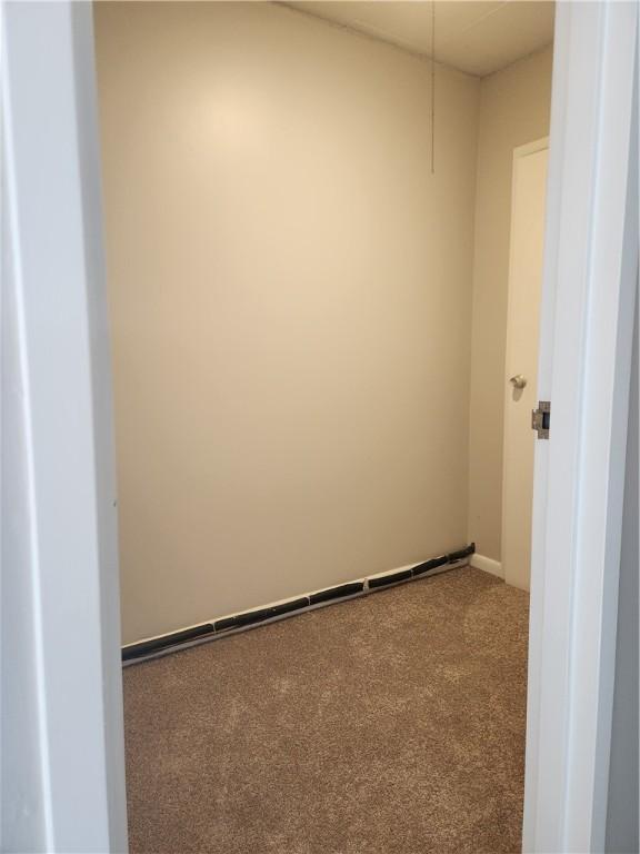 unfurnished room with carpet floors and baseboards