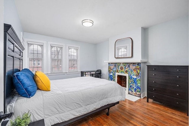 bedroom featuring a fireplace and wood finished floors