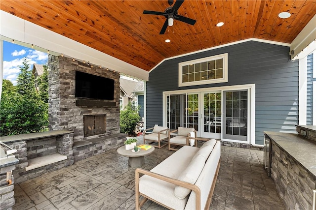 view of patio with a ceiling fan and an outdoor living space with a fireplace