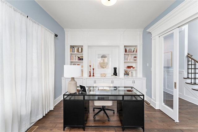 office space with dark wood-style floors, built in shelves, and baseboards