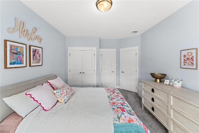 bedroom with visible vents, dark carpet, and a closet