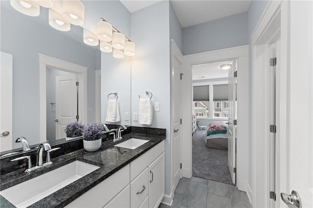 ensuite bathroom with tile patterned floors, a sink, ensuite bathroom, and double vanity