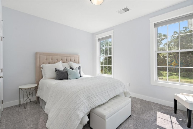 carpeted bedroom featuring baseboards and visible vents