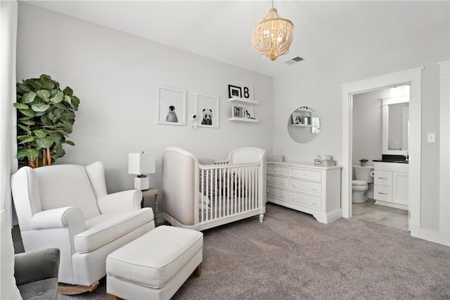 bedroom with light carpet, baseboards, visible vents, connected bathroom, and a nursery area