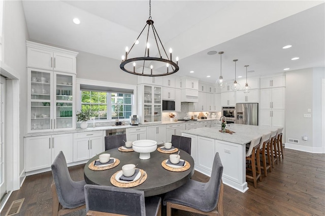 dining area featuring visible vents, a chandelier, dark wood-type flooring, and recessed lighting