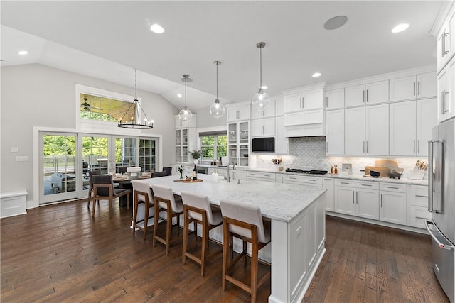 kitchen featuring appliances with stainless steel finishes, white cabinetry, backsplash, and dark wood-style floors