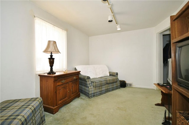 living area with rail lighting, carpet, visible vents, and baseboards