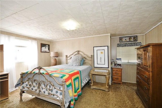 bedroom with carpet, crown molding, and wooden walls