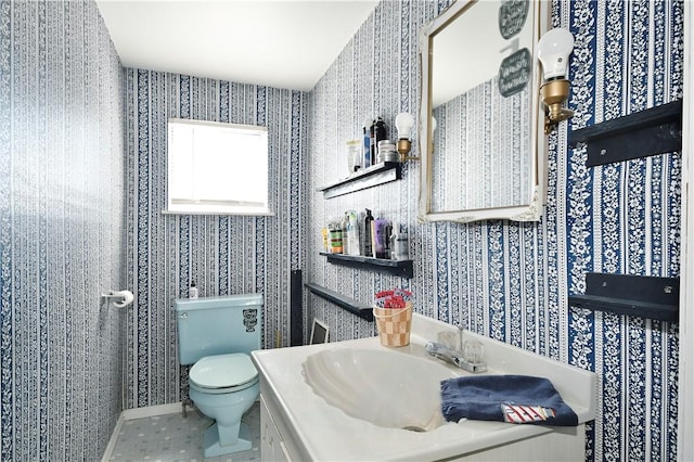 bathroom with tile patterned flooring, vanity, toilet, and wallpapered walls