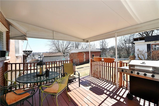 wooden terrace with outdoor dining area and area for grilling