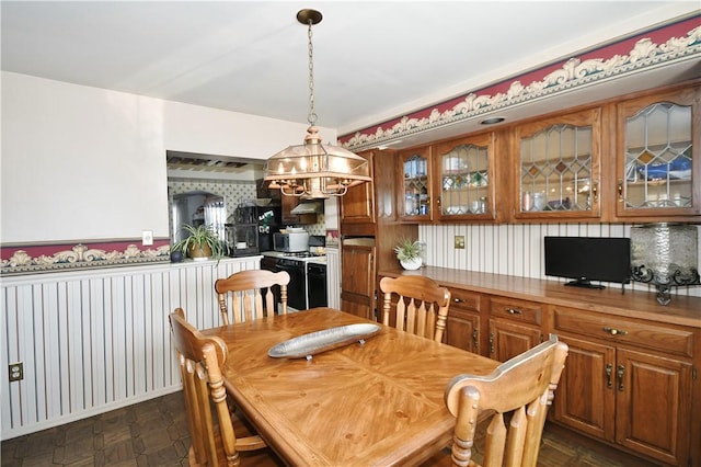 dining room with wallpapered walls and wainscoting