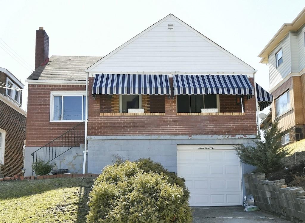 view of home's exterior with a garage, brick siding, and a chimney