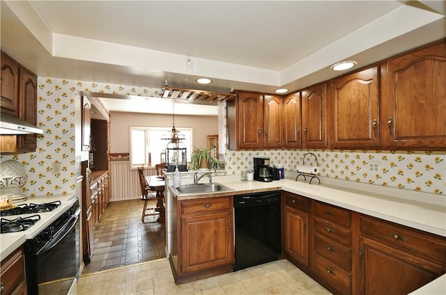 kitchen with range with gas cooktop, light countertops, wainscoting, a sink, and dishwasher