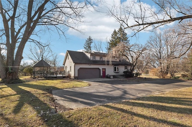 view of side of property with a yard, driveway, and an attached garage