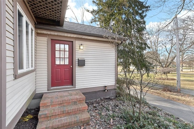 entrance to property featuring a shingled roof