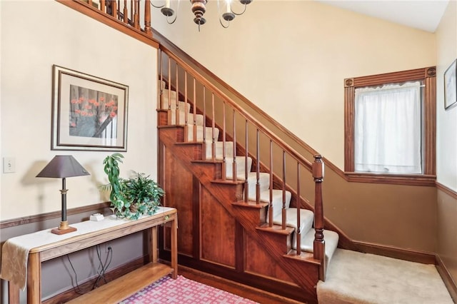 stairs with vaulted ceiling, wood finished floors, and baseboards