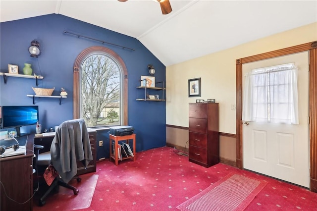 carpeted office space featuring vaulted ceiling and a ceiling fan