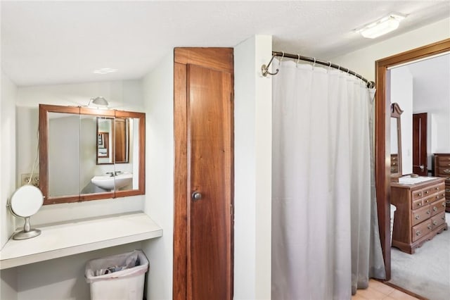 bathroom with lofted ceiling, a sink, and a shower with shower curtain