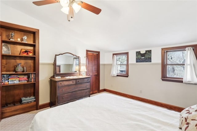 carpeted bedroom featuring vaulted ceiling, ceiling fan, a closet, and baseboards