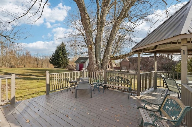 wooden terrace featuring an outbuilding and a lawn