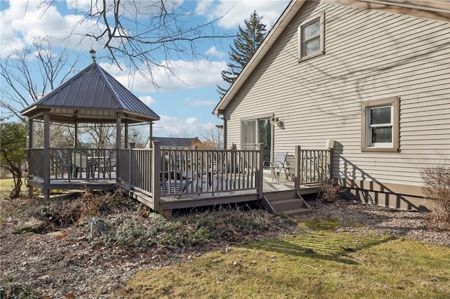 wooden deck featuring a lawn and a gazebo