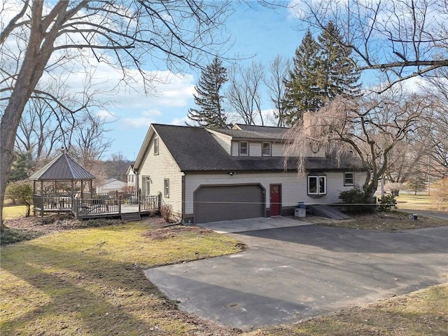 view of property exterior featuring a garage, a gazebo, a yard, roof with shingles, and driveway